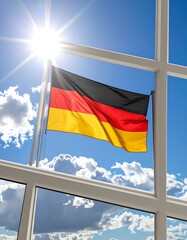 German flag waving in the sunshine, seen through a window
