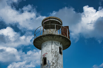 Old Weathered Lighthouse Against Blue Sky