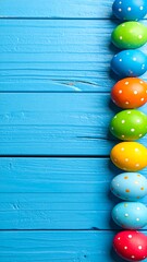 Colorful Easter eggs in a line on a blue wooden surface