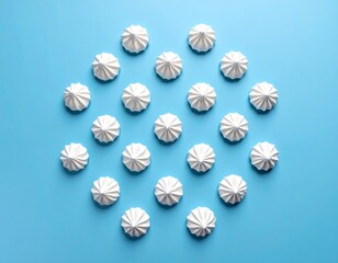 White meringue cookies arranged in a circle on a vibrant blue background (1)