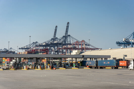 Entrance facade of the Manzanillo Colima port with control booths and cargo trucks with containers. Logistic access and port security. Mexico March 02 2026
