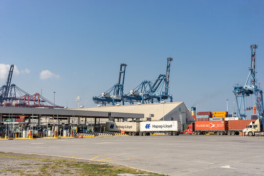 Entrance facade of the Manzanillo Colima port with control booths and cargo trucks with containers. Logistic access and port security. Mexico March 02 2026