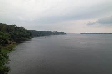 Calm waters reflect overcast skies in an Amazonian river landscape