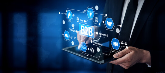 A professional in a suit interacts with a digital touchscreen displaying B2B icons and connection graphics, symbolizing modern business solutions and innovation. Tessel