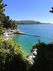 Fototapeta premium Bečići, Budva, Montenegro- 10 June, 2024:Walking through the beautiful resort town of Becici on a sunny summer day - sea, mountains, lots of greenery and different flowers.