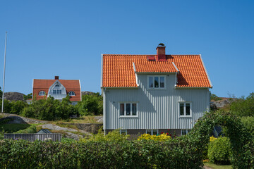 White houses with orange tiled roofs under blue sky.