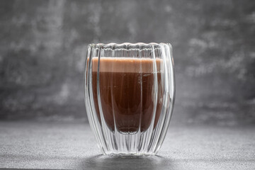 Glass of hot chocolate. A transparent glass filled with rich hot chocolate.