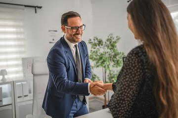 Business people shaking hands celebrating successful agreement in office