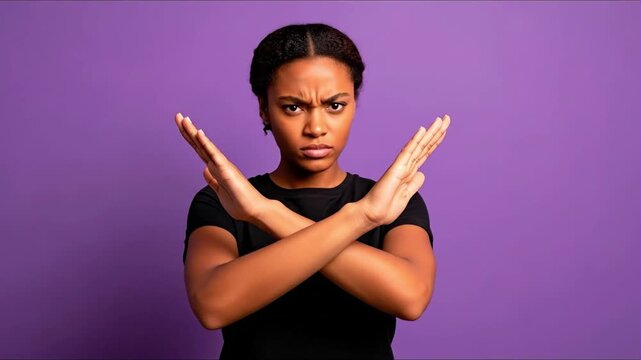 Woman with crossed arms scowls against purple background
