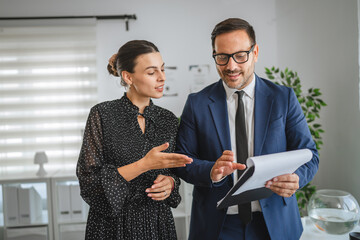 Business colleagues discussing documents, collaborating in office