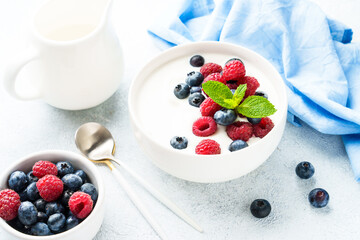 Yogurt with fresh berries in white bowl.