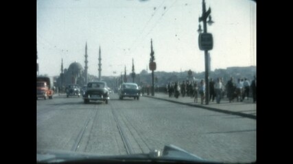 Driving on Galata Bridge 1964 - First person view from a car as it drives south on Galata Bridge, approaching the New Mosque, Yeni Cami, in Istanbul, Turkey in 1964. 