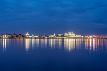 Fototapeta premium Night view of the Kazan Kremlin. Illuminated buildings and lanterns on the river bank,