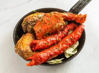 Tandoori Mixed Grill Platter with Chicken Tikka and Seekh Kebab in a Frying Pan isolated on marble background side view of Pakistani cousin