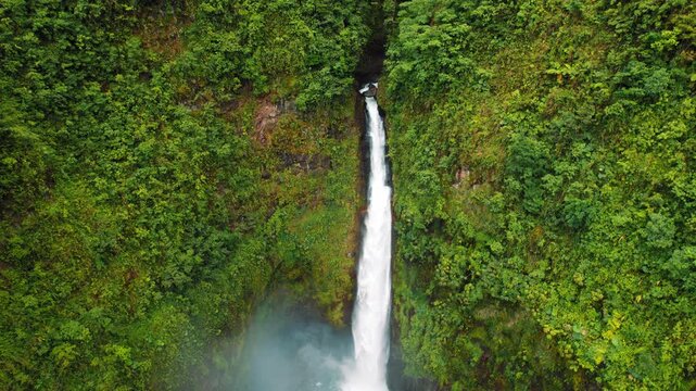 Tall waterfall cascading into a turquoise pool in lush Costa Rican jungle