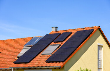 Rote Hausd&auml;cher mit Solarzellen und Solarthermieanlage