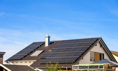 Einfamilienhaus mit Solardach vor blauem Himmel