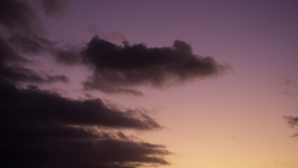 Purple sunset sky with dramatic clouds and evening light
