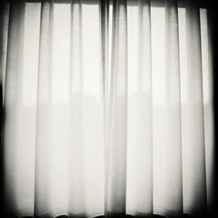 Obraz premium Soft grey curtains hang gracefully, allowing natural light to filter through. The light casts subtle shadows, enhancing the peaceful ambiance within the cozy space Generative AI