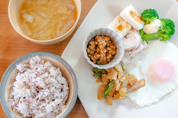 Healthy Japanese breakfast with natto, egg, chicken breast and vegetables
