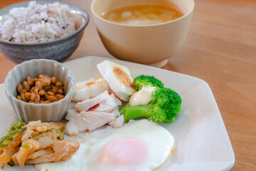 Healthy Japanese breakfast with natto, egg, chicken breast and vegetables
