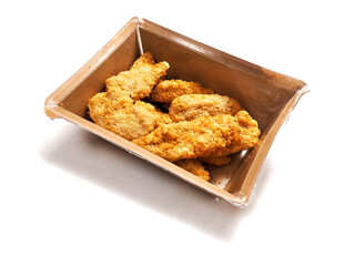 Uncooked chicken goujons or tenders in a card board box on white background. Popular classic chicken dish made from pieces of breast and breadcrumbs. Traditional ready to cook poultry product.