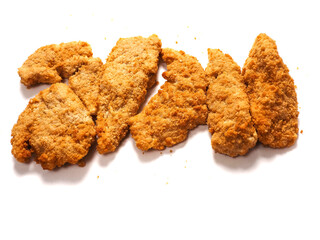 Uncooked chicken goujons or tenders in on white background. Popular classic chicken dish made from pieces of breast and breadcrumbs. Traditional ready to cook poultry product.
