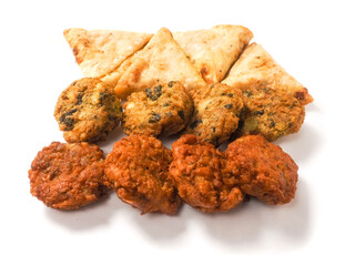 Indian style starter food selection of samosa, bhajis and pakoras on white background. Party sharing finger food variety made from fine products and aromatic spices. Special orient vibe.