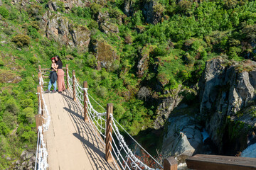 Amigas posando en una pasarela junto a un pozo con humos, Friends posing on a walkway next to a smoky well