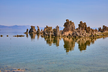 Fototapeta premium Mono Lake Tufa Formations Reflected in Calm Water with Distant Mountains
