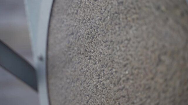 A clear view of dry cattle feed pellets visible through the transparent hatch of a steel feed container. This close-up highlights the texture and uniform size of feed used in automated feeding systems