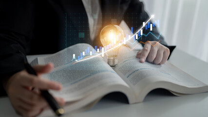 A business professional studies investment strategies with an open book and glowing light bulb concept, analyzing stock market data for creative growth insights. Impute