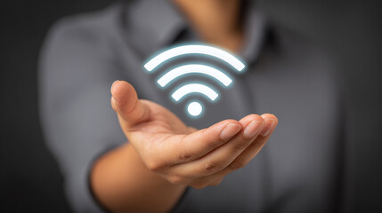 Hand reaching toward a floating holographic signal representing connectivity in a modern workspace setting