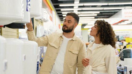 Couple discussing a purchase in an appliance store on Black Friday