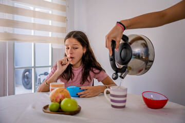 Young woman enjoying healthy breakfast independently at home