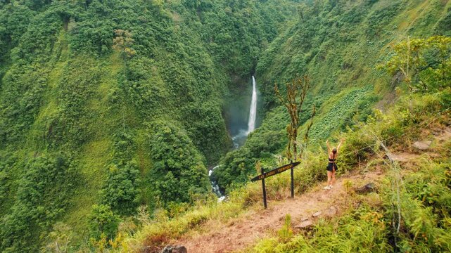 Traveler woman at Las Lajas viewpoint enjoying view of waterfall in Costa Rica