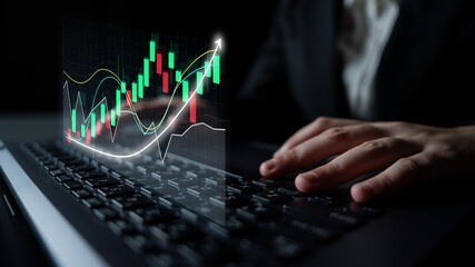 A business professional uses a laptop to analyze financial market trends, featuring a colorful...