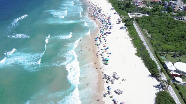 Aerial view of Brava Beach in Florian&oacute;polis Santa Catarina luxurious paradise with mountains  tourist spot with many people and umbrellas on the sand.