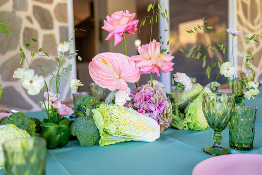 A Vibrant Table Arrangement Featuring Colorful Flowers and Fresh Vegetables for a Delightful Dining Experience