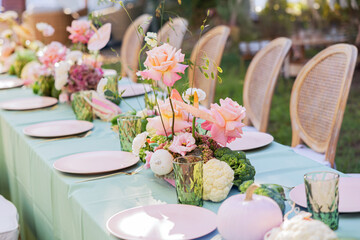 A Beautifully Decorated Outdoor Dining Table Featuring Elegant Floral Arrangements and Seasonal Produce for an Inviting Gathering