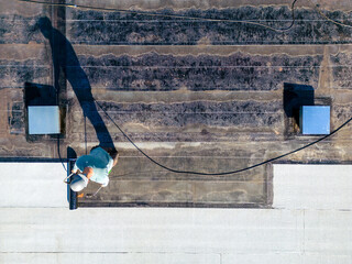 Roofer applying torch to bitumen membrane on torch down roof
