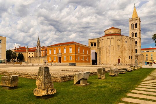 Archaeological remains of Roman forum in Zadar, Croatia, with church of St. Donatus and cathedral bell tower on summer day, highlighting religious tradition and cultural heritage preserved in old town