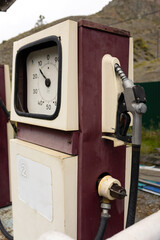 An old-fashioned gas station with mechanical hands and a meter. The gas station is located against the backdrop of the natural Altai mountains.