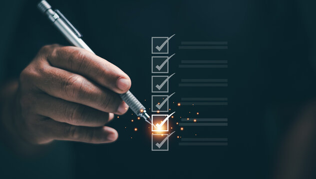 Checklist concept. Businessman holding pen to checking task on glowing digital list. Symbolizing productivity, task management, goal setting, planning and business efficiency in professional workflow.