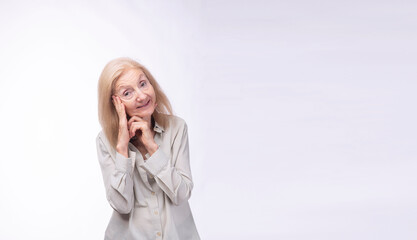 Cheerful elderly 70s woman holding hands own face standing smile over isolated white background....