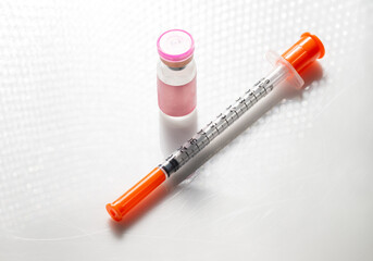 Close up of Vial with Injectable Compounds Next to Syringe