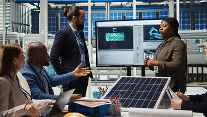 Managers in photovoltaics plant office reviewing solar technology reports. Shareholders reading discussing future investment opportunities in green energy production, camera A