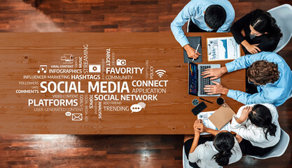 A diverse team gathers around a wooden table to discuss social media strategies, analyzing charts and graphs, showcasing their collaborative efforts in a modern workspace. Amity