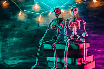 Halloween Book Mockup. Skeletons Sitting on Books with String Lights. Place for Text.Halloween...