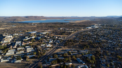High angle shot of a city near a lake and mountains on a clear and sunny day